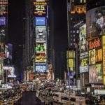 New York Times square at night, brightly lit and busy.