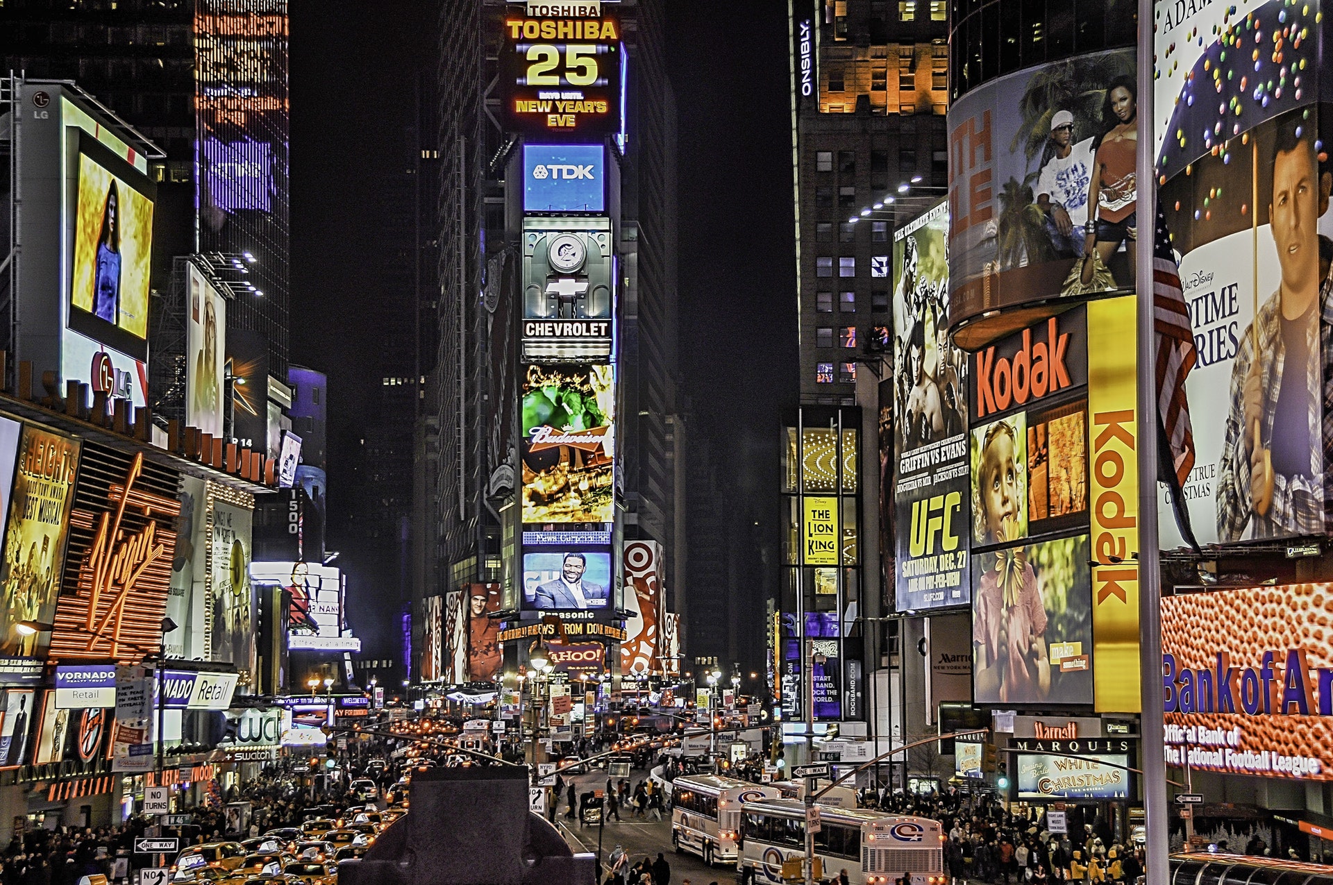 New York Times square at night, brightly lit and busy.