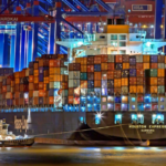 A tugboat pulls a large cargo ship into port