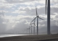 A line of wind turbines along a cost