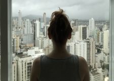Woman looking at city outside window
