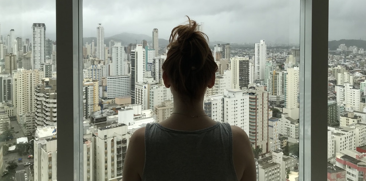 Woman looking at city outside window