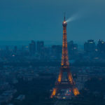 Eiffel Tower spotlight against a stormy evening sky