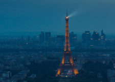 Eiffel Tower spotlight against a stormy evening sky
