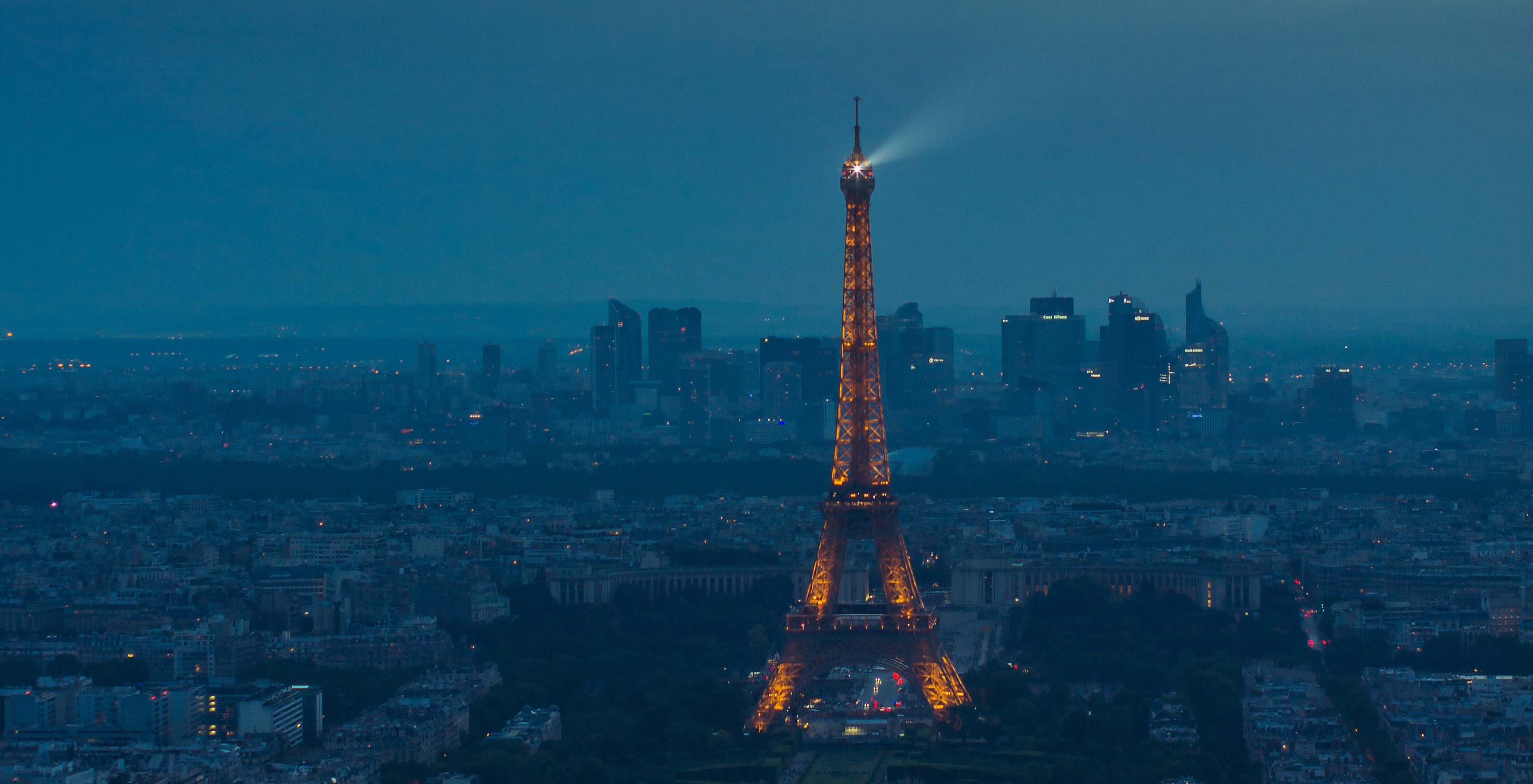 Eiffel Tower spotlight against a stormy evening sky