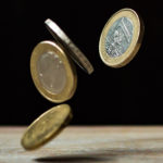 Euro coins bouncing off a table