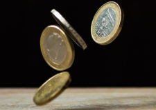 Euro coins bouncing off a table