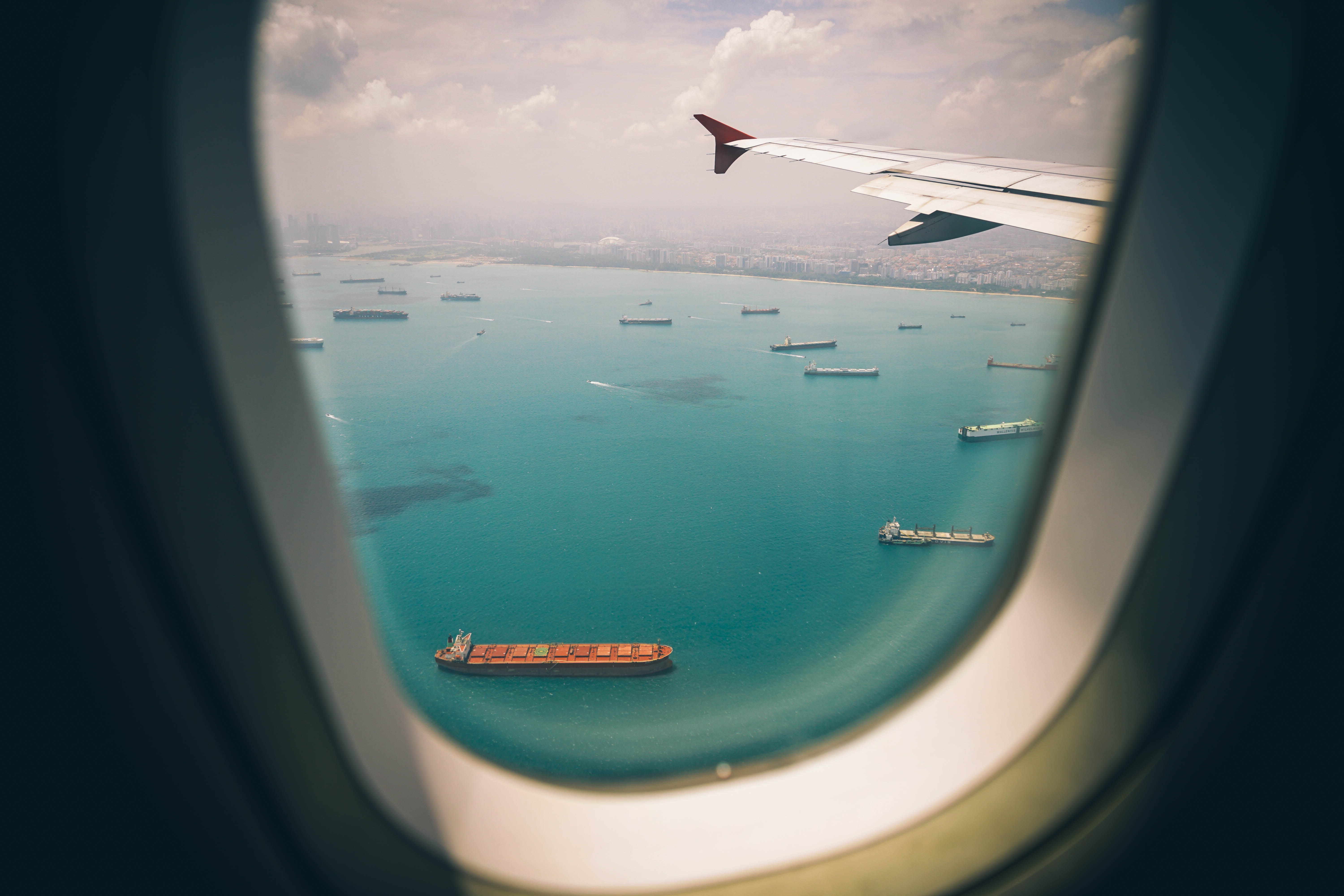 View of port and cargo ships from airplane window