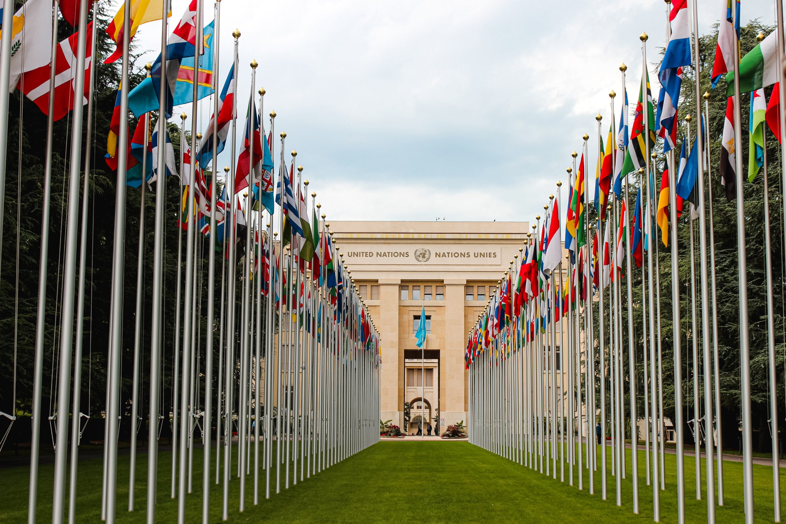Two rows of national flags outside of a UN building